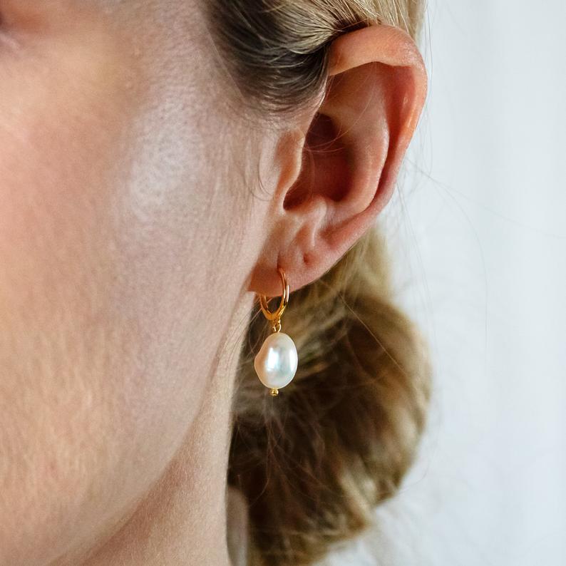 olivia le blond model wearing emme gold hoop earrings with fresh water pearl charms dangling from gold hoop earrings